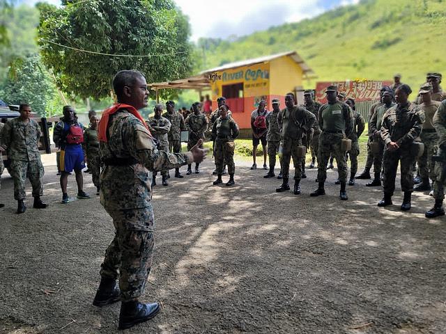El Brigadier Markland Lloyd de la FDJ habla a los miembros del DART de las Fuerzas de Defensa de Jamaica, tras un ejercicio final, en el remoto terreno montañoso del norte de Jamaica. Los alumnos del DART realizaron un entrenamiento intensivo de una semana enfocado en el TCCC, la respuesta a los disturbios civiles, y el rescate en inundaciones y aguas rápidas. (Foto: FDJ/571st MSAS)