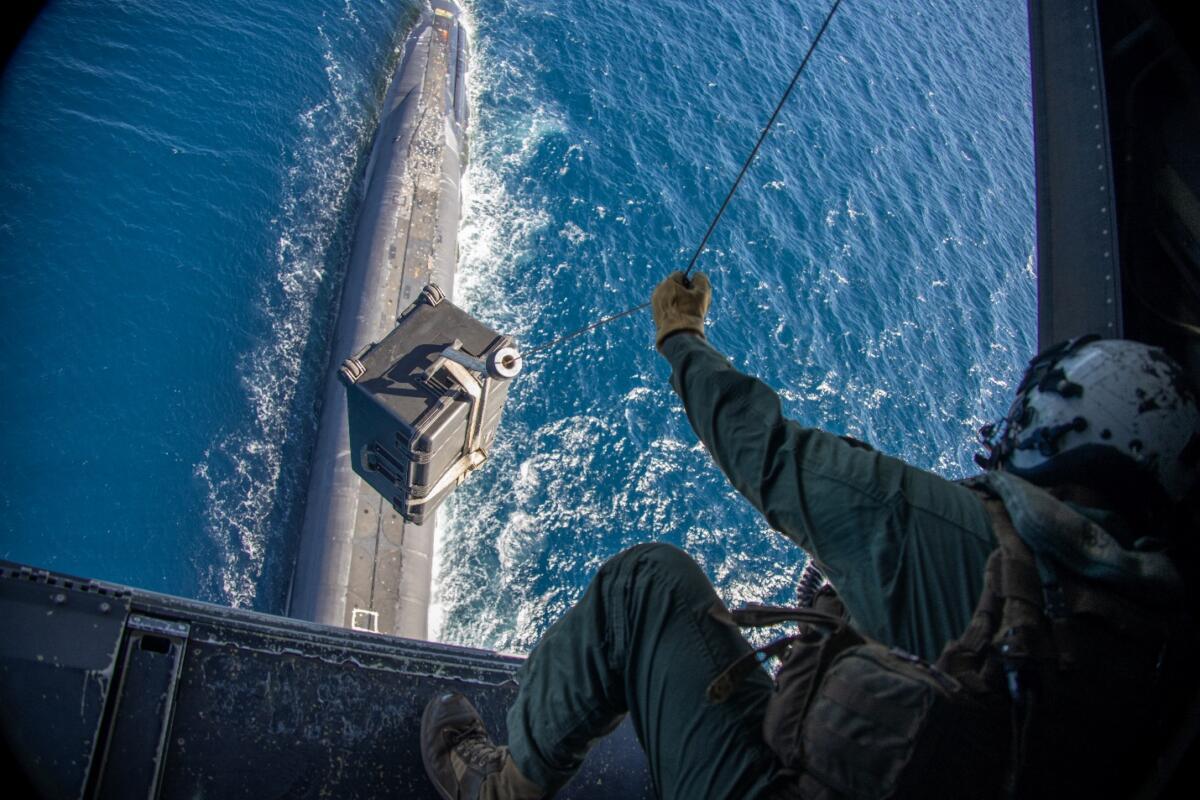 U.S. Marine Corps Corporal Colton Davis, a crew chief with Marine Medium Tiltrotor Squadron 165, Marine Aircraft Group 16, 3rd Marine Aircraft Wing, conducts a vertical replenishment to resupply the U.S. Navy Ballistic Missile submarine USS Henry M. Jackson (SSBN 730) operating off the coast of southern California, July 26, 2022. (Photo: U.S. Marine Corps Lance Corporal Daniel Childs)