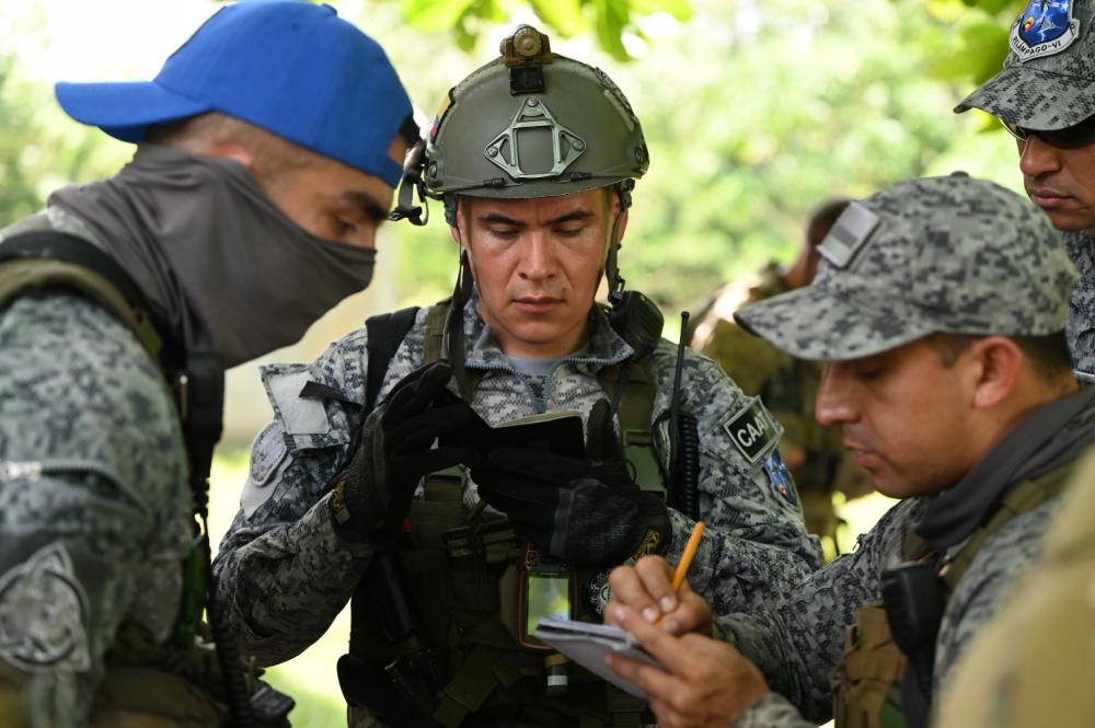 Colombian Air Force GROEA air and terminal attack controllers write down coordinates before a simulated airstrike during Exercise Relámpago VI, near Palenquero Air Base, Colombia, July 13, 2021. The GROEA typically have more than one expertise and are referred to as commandos. The exercise and training with the U.S. TACPs will give the commandos the joint terminal attack controller (JTAC) capability. (Photo: U.S. Air Force Technical Sergeant Matthew Lotz)O exercício e o treinamento com os TACPs dos EUA darão aos comandos a capacidade conjunta do controlador de ataque terminal (JTAC).