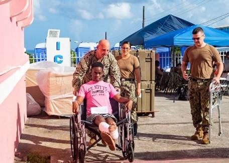Continuing Promise 2019: A U.S. Navy sailor assigned to the hospital ship USNS Comfort (T-AH 20) escort a St. Kitts patient at a temporary medical treatment site in St. Kitts and Nevis on October 6, 2019. During the USNS Comfort five-month deployment from June to November 2019 to Colombia, Costa Rica, Dominican Republic, Ecuador, Grenada, Haiti, Jamaica, Panama, Peru, Saint Lucia, St. Kitts and Nevis, and Trinidad and Tobago, medical team supported regional partners in response to the regional impacts of the political and economic crisis in Venezuela. (Photo: U.S. Navy Mass Communication Specialist Third Class Brendan Fitzgerald)
