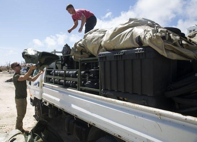 U.S. Marine Cpl. Kyler S. Barrett, left, a landing support specialist with Joint Task Force-Leeward Islands (JTF-LI), and Cpl. Bryson C. Carnell, a heavy equipment operator with JTF-LI, unload components of a Lightweight Water Purification System from a truck at Orient Beach, Saint Martin on September 16th. The marines arrived to assess possible locations to set up their LWPS to produce drinking water for people on the island affected by Hurricane Irma. (Photo: U.S. Marine Corps Corporal Melanie Kilcline)