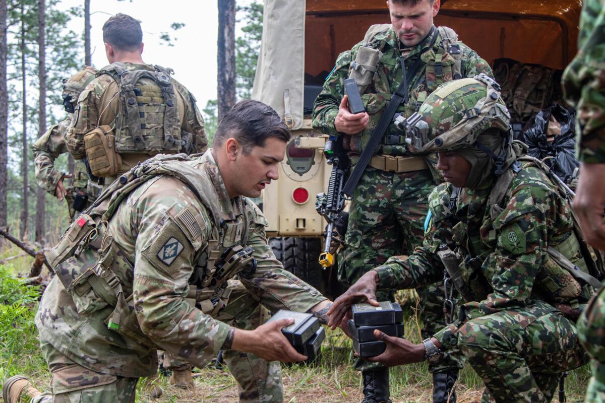 A U.S. Army advisor assigned to Second Battalion, 1st Security Force Assistance Brigade, gives batteries to a Colombian Army partner during a JRTC rotation at Fort Polk, Louisiana, April 25, 2023. (Photo: U.S. Army Major Jason Elmore)