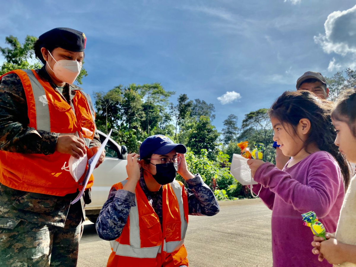 A Guatemalan Army soldier shows a girl how to properly use a mask to protect herself from COVID-19. (Photo: Guatemalan Army)
