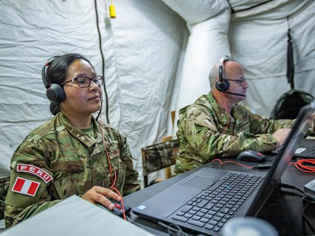 Una participante de la Fuerza Multinacional del Sur (MNFS) de Perú (izq.) realiza un análisis, y  prepara su informe. (Foto: Relaciones Públicas del Ejército Sur de los EE. UU.)