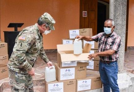 El Coronel del Ejército de los EE. UU. John Litchfield, comandante de la Fuerza de Tarea Conjunta Bravo (izquierda), y el Sr. Francisco Méndez, alcalde de Lejamaní, municipio del departamento de Comayagua, Honduras, desempaquetan suministros médicos el 11 de agosto de 2020. La donación, a través del Programa de Asistencia Humanitaria del Comando Sur de los EE. UU., fue parte de cuatro entregas que se efectuaron en los departamentos de La Paz y Comayagua, e incluyó equipamiento de protección personal y suministros médicos, para ayudar a profesionales locales de la salud en la lucha contra el COVID-19 en la región. (Foto: Maria Pinel/JTF-Bravo)
