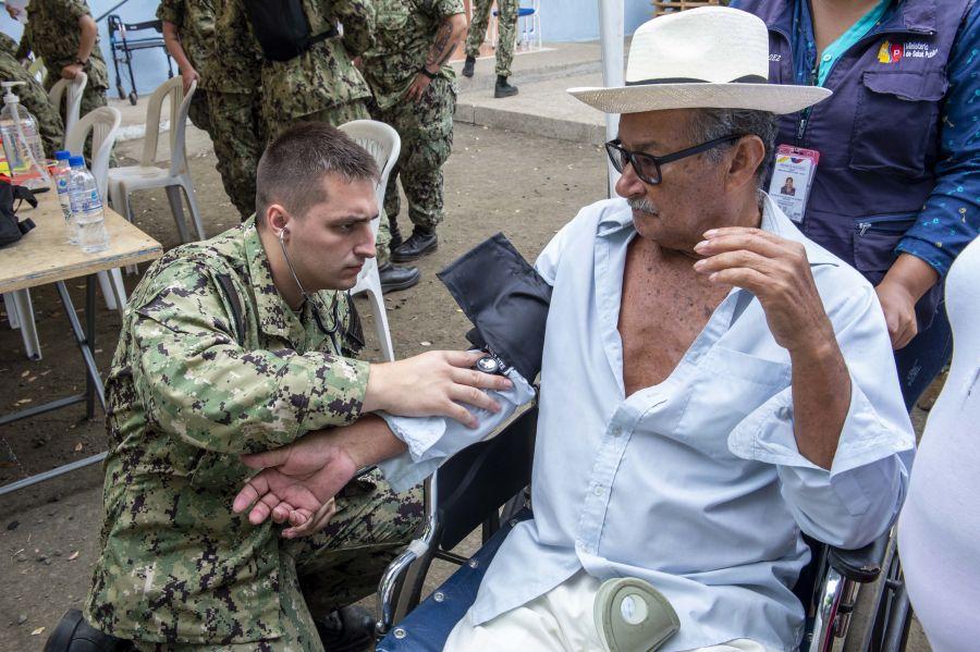 El Contramaestre de Tercera Clase de la Marina de los EE. UU.  Lance Gilinsky, de Yelm, Washington, atiende a un paciente en un puesto médico temporal. (Foto: Contramaestre Segunda Clase de la Marina de los EE. UU. Bobby Siens)