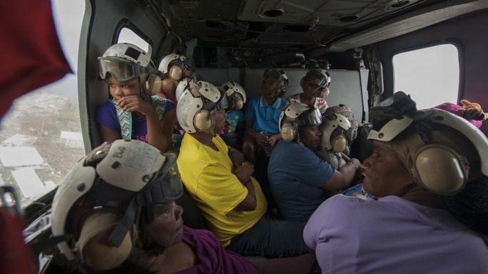 Residentes de Dominica vuelan en un helicóptero MH60s Sea Hawk, mientras se preparan para evacuar la isla hacia las islas cercanas de Martinica y Guadalupe. El Departamento de Defensa de los EE. UU. está apoyando a la Agencia de los EE. UU. para el Desarrollo Internacional, agencia federal de ayuda a los afectados por el huracán María, para reducir el sufrimiento al mínimo. La agencia es un componente del esfuerzo de respuesta general de todo el Gobierno. (Foto: Contramaestre de 3.a Clase de la Marina de los EE. UU. Sean Galbreath) 