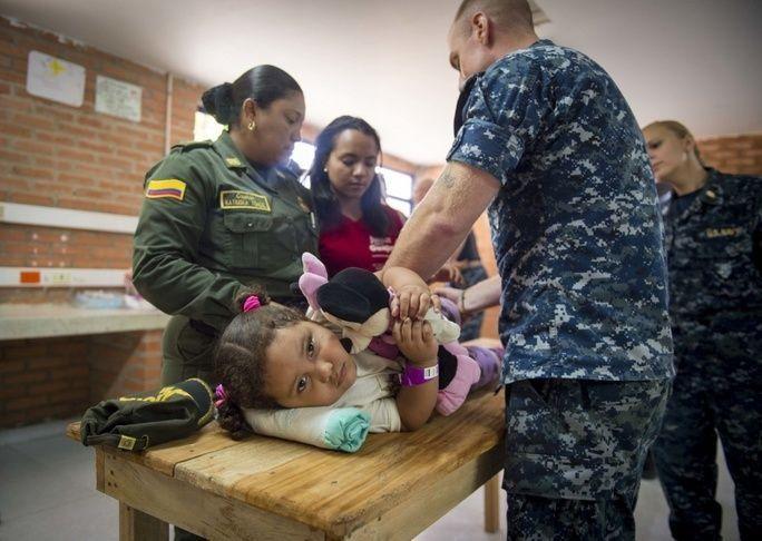 Hospital Corpsman 2nd Class Joshua Crisano, assigned to Naval Hospital Jacksonville, Florida, teaches physical therapy stretches to the mother of a Colombian child at the Continuing Promise 2017 medical site in Mayapo, Colombia. (Photo: Mass Communication Specialist 2nd Class Shamira Purifoy, U.S. Navy)