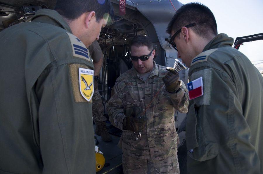U.S. Air Force Staff Sergeant Stefan Adams, 55th Rescue Squadron special mission aviator instructor, shares alternate insertion and extraction device information on a HH-60G Pave Hawk during an H-60 Subject Matter Exchange with Chilean airmen at Davis-Monthan Air Force Base. (Photo: U.S. Air Force Technician Sergeant Angela Ruiz)