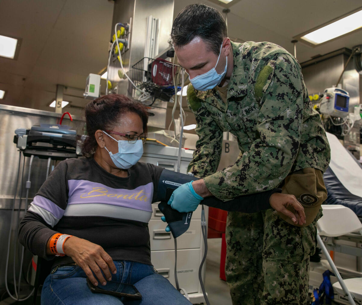 O Cabo Cody Gilman, da Marinha dos EUA, designado para o navio hospital USNS Comfort (T-AH 20), toma os sinais vitais de um paciente, durante o processo de admissão de pacientes do navio em Cartagena, Colômbia, em 12 de novembro de 2022. (Foto: Terceiro-Sargento Juel Foster, da Marinha dos EUA)