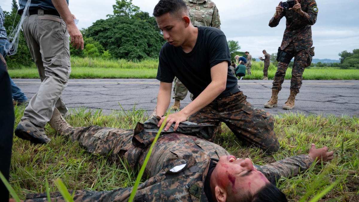 A Salvadoran medic (top middle) checks a simulated plane crash survivor (bottom middle) for immediate injuries at Ilopango Air Base, El Salvador, June 16, 2022. Resolute Sentinel 22 is an exercise designed to prepare military medical professionals to deploy and conduct joint operations under austere conditions. (Photo: U.S. Air Force Staff Sergeant Stuart Bright)