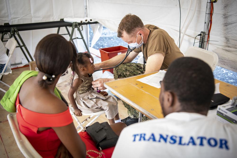 U.S. Navy Commander Michael Cunningham, a pediatric cardiologist, from Chesapeake, Virginia, provides medical care during Continuing Promise 2022 (CP22) at a medical site in Jeremie, Haiti, December 12, 2022. Comfort is deployed to U.S. Naval Forces Southern Command/U.S. 4th Fleet in support of CP22, a humanitarian assistance and goodwill mission conducting direct medical care, expeditionary veterinary care, and subject matter expert exchanges with five partner nations in the Caribbean, Central and South America. (Photo: U.S. Navy Mass Communication Specialist First Class Benjamin Lewis)