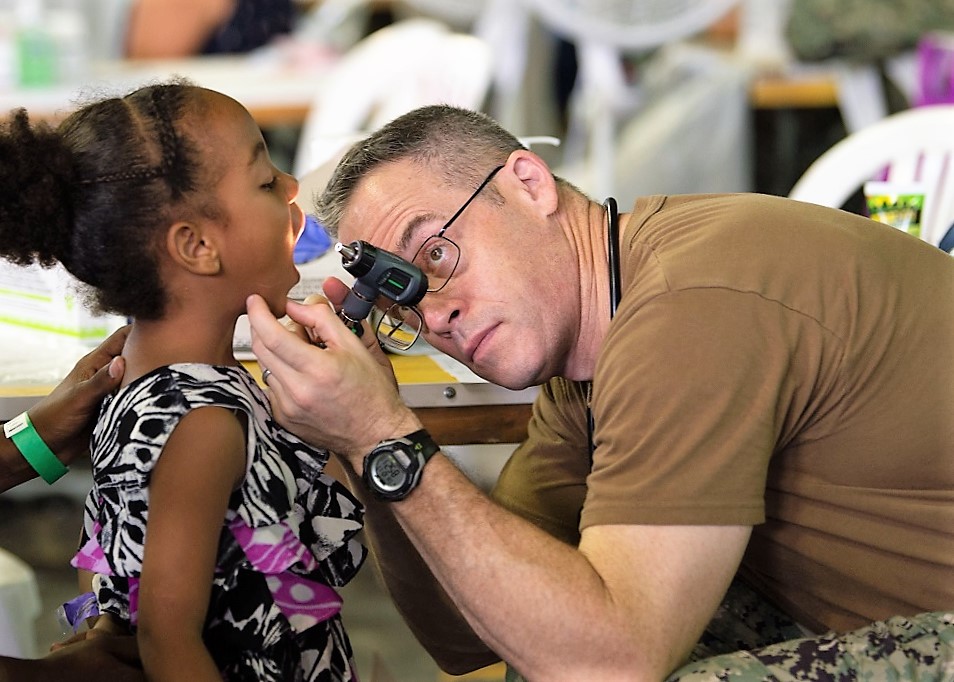 El Capitán de Navío de la Marina de los EE. UU. Michael Sullivan, médico asignado al USNS Comfort, realiza un chequeo general a una niña, en un puesto temporal de atención médica en Santo Domingo, República Dominicana. (Foto: Contramaestre Tercera Clase de la Marina de los EE. UU. Danny Ray Nuñez Jr.)