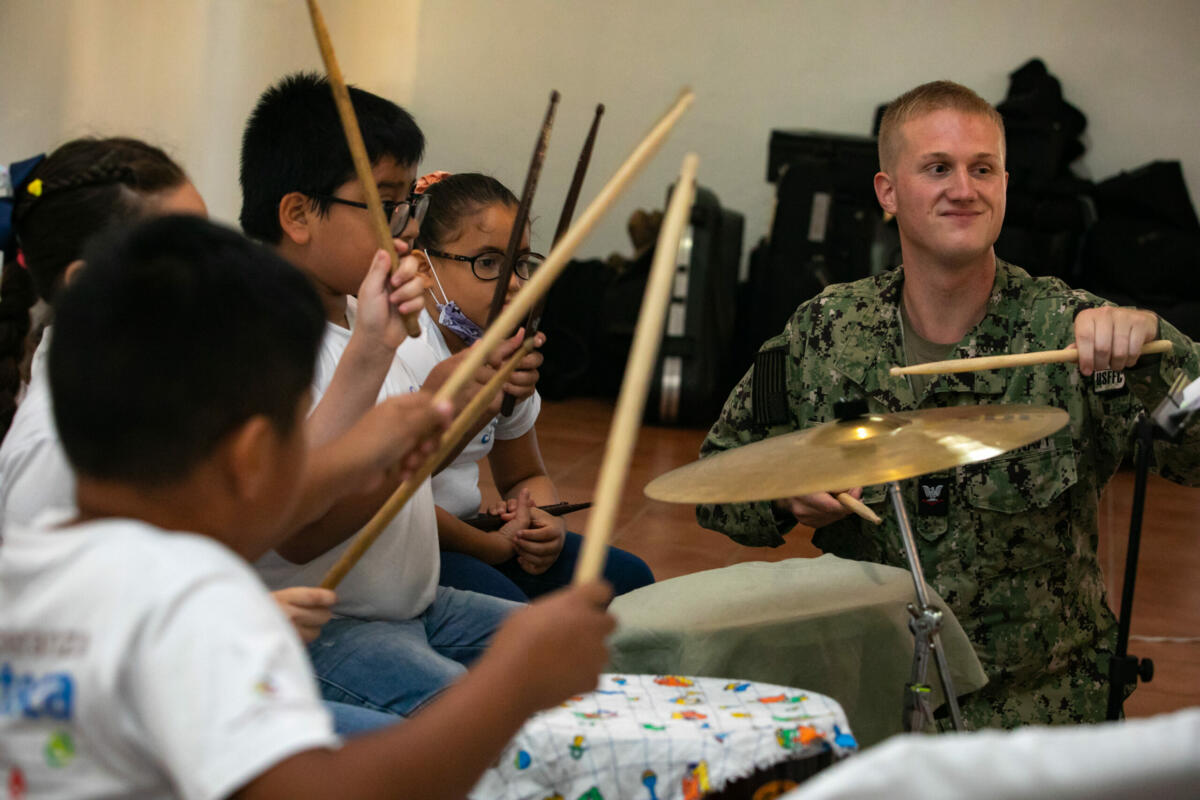U.S. Navy Musician Third Class Erik Barnes, a member of the U.S. Fleet Forces band attached to the hospital ship USNS Comfort (T-AH 20), gives percussion lessons to students from the Esperanza Azteca band during a community relations event in Puerto Barrios, Izabal, Guatemala, October 28, 2022. (Photo: U.S. Navy Mass Communication Specialist Second Class Juel Foster) 