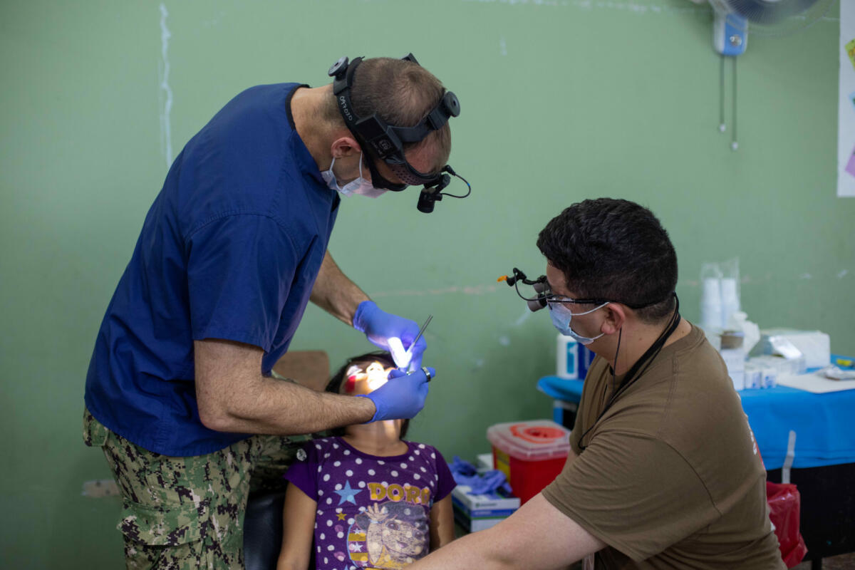 El Capitán de Fragata de la Marina de los EE. UU.  Pete Cervenka, cirujano oral y maxillofacial, y el Teniente de Navío Kevin Campbell, dentista general, realizan atención dental a un paciente en una clinica en Tegucigalpita, Honduras, durante la misión Promesa Continua 22, el 1.o de noviembre de 2022. (Foto: Cabo del Ejército de los EE. UU. Génesis Gómez)