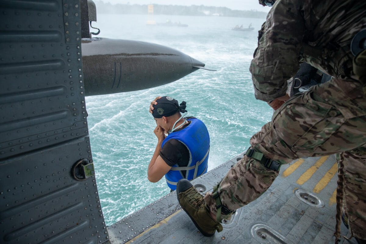 A Honduran team member leaps into the water from a UH-60 Blackhawk helicopter during a helocast exercise at FC24 in Fort Sherman, Panama, May 21, 2024. The helocast portion of the competition involved riding in a helicopter out over the Atlantic Ocean before making an approximately 10-foot jump into the water to begin the event. (Photo: U.S. Army National Guard Sergeant Olivia Lauer)