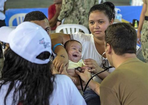 El Contramaestre Tercera Clase de la Marina de los EE. UU. Nicholas Mauro examina a un niño en un puesto temporal de atención médica en Santo Domingo, República Dominicana. (Foto: Contramaestre Segunda Clase de la Marina de los EE. UU. Julio Martinez Martinez)