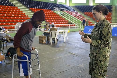 La Contramaestre Tercera Clase de la Marina de los EE. UU.  Madison Kirk enseña a un paciente a utilizar una andadera, en un puesto temporal de atención médica en Santo Domingo, República Dominicana. (Foto: Especialista del Ejército de los EE. UU. Dedrick Johnson)