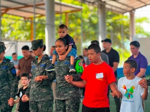 Cadets from the Honduran Military Aviation Academy hold hands with children during recreational activities at Nazareth Orphanage, highlighting the spirit of partnership, service, and community engagement that brought together Honduran and U.S. personnel for the event.