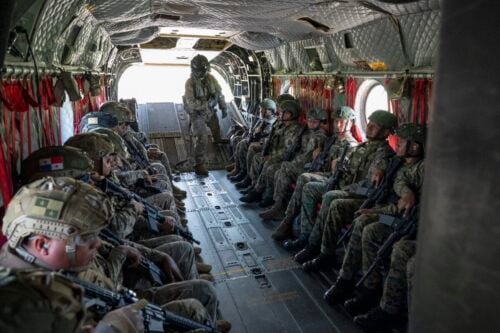 Panamanian security forces sit in a CH-47 Chinook as U.S. Army Sergeant James Coppola (standing) 1st Battalion, 228th Aviation Regiment aircrewman, provides instructions prior to liftoff during PANAMAX Alpha Phase I at Panama Pacifico International Airport, Panama, July 14, 2025. (Photo: U.S. Air Force Staff Sergeant Sadie Colbert)