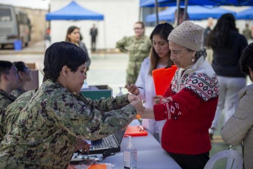 U.S. Navy Hospital Corpsman Second Class Ajai Rios, from Los Angeles, assigned to USNS Comfort, checks a patient into a temporary medical treatment site. (Photo: U.S. Navy Mass Communication Specialist Second Class Julio Martinez Martinez)