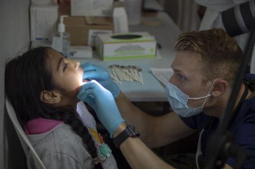 U.S. Army Captain Walter Hinman, a dentist assigned to USNS Comfort, conducts a dental exam while Peruvian Navy officers observe during a subject matter expert exchange at a temporary medical treatment site. (Photo: U.S. Navy Mass Communication Specialist Second Class Julio Martinez Martinez)