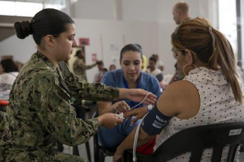 U.S. Navy Hospital Corpsman Marissa Monroe, from Bakersfield, California, assigned to the USNS Comfort, checks a patient’s blood pressure. The Comfort’s crew is working with health and government partners in Central America, South America, and the Caribbean to provide care on the ship and at land-based medical sites, helping to relieve pressure on national medical systems strained by an increase in Venezuelan migrants. (Photo: U.S. Army Specialist Jacob Gleich)