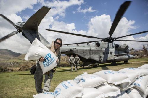 Militares estadounidenses con la Fuerza de Tarea Conjunta Matthew distribuyen bolsas de arroz en Les Anglais, Haití, el 13 de octubre de 2016. Tras seis días de operaciones de abastecimiento, la FTC Matthew logró distribuir más de 160 toneladas de suministros por medio de helicópteros CH-53E Super Stallion y CH-47 Chinook. (Foto: Kimberly Aguirre/Cuerpo de la Infantería de Marina de los EE. UU.) 