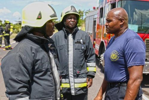 Lesroy Caines, (right) the station officer for Robert L. Bradshaw International Airport fire house, recieves a report from his firefighters while responding to the plane crash scenario during Tradewinds 2018 June 9, 2018, in Basseterre, St. Kitts. (U.S. Army National Guard photo by Staff Sgt. Shane Hamann, 102d Public Affairs Detachment)