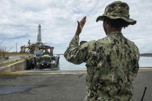 Boatswain’s Mate 2nd Class Chelsea Cowans, assigned to Beach Master Unit (BMU) 2, guides a Humvee off the deck of a landing craft utility in Puerto Rico, on September 25th. The Department of Defense is supporting the Federal Emergency Management Agency (FEMA), the lead federal agency in helping those affected by Hurricane Maria, to minimize suffering and is one component of the overall whole-of-government response effort. (Photo: U.S. Navy Mass Communication Specialist 1st Class Blake Midnight)