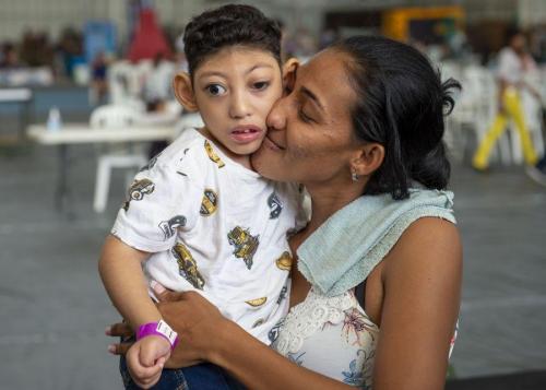 Yohainnys Vaíguez, una madre venezolana, abraza a su hijo de cuatro años con parálisis cerebral, en una sesión de fisioterapia en un puesto temporal de atención médica. (Foto: Marinero Primero de la Marina de los EE. UU. Jordan R. Bair)