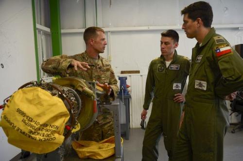 U.S. Air Force Master Sergeant Edward Bellus, 55th Helicopter Maintenance Unit, talks to Chilean Air Force Major Javier Del Rio and Lieutenant Erwin Caro, about helicopter engine maintenance during an H-60 Subject Matter Exchange at Davis-Monthan Air Force Base, Arizona, August 8, 2019. (Photo: U.S. Air Force Technician Sergeant Angela Ruiz)