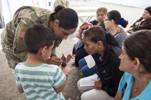 U.S. Army Major Jasmin Gregory, from Lawton, Oklahoma, teaches patients about public health at a temporary medical treatment site. (Photo: U.S. Navy Mass Communication Specialist Second Class Bobby Siens)