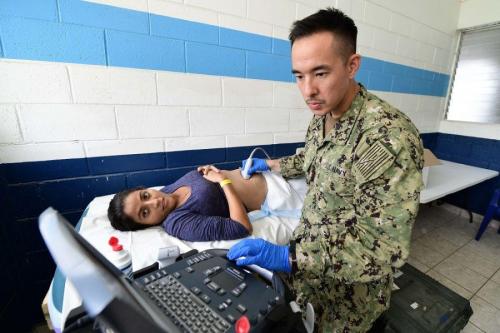 O Capitão-de-Corveta da Marinha dos EUA Matthew Lee realiza um exame de ultrassom em uma gestante guatemalteca em Puerto Barrios, Guatemala, em 17 de abril de 2018. (Foto: Terceiro-Sargento da Marinha dos EUA Kayla Cosby, especialista em Comunicação de Massa)