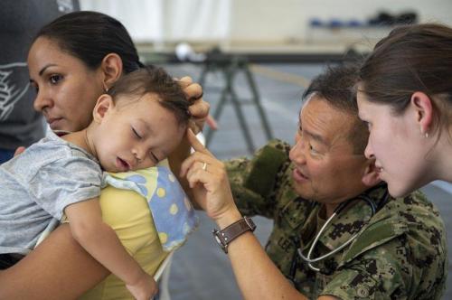 U.S. Navy Captain Gabriel Lee, a pediatrician assigned to Hospital Ship USNS Comfort examines a young boy with scabies at a temporary medical treatment site. (Photo: U.S. Navy Mass Communication Specialist Second Class Julio Martinez Martinez)
