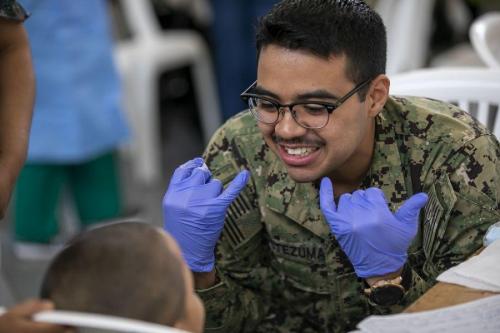 El Contramaestre de la Marina de los EE. UU.  Freddy Moctezuma, de Las Vegas, Nevada, explica a un niño las bases de la higiene dental. (Foto: Especialista del Ejército de los EE. UU. Jacob Gleich)
