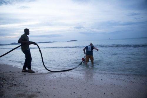 U.S. Marine Corps Lance Corporal Eric C. Mitts and U.S. Marine Corps Corporal Brandon Fenley, both water support technicians with Joint Task Force-Leeward Islands, drag a hose for a Lightweight Water Purification System into the ocean at a water distribution site on Saint Martin, on September 14th. (Photo: U.S. Marine Corps Sergeant Ian Leones)St. Martin 4: A U.S. marine with Joint Task Force-Leeward Islands helps Anne Galegor, a representative of the U.S. Agency for International Development's Office of U.S. Foreign Disaster Assistance, fill containers with water at a water distribution site in Saint Martin, on September 15th. (Photo: U.S. Army Captain Trisha Black)