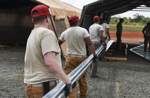 Engenheiros destacados com SOUTHCOM carregam peças de uma treliça que irá dar suporte ao telhado de um prédio, em um dos cinco canteiros de obras na província de Darién, no Panamá, em 14 de abril de 2018. (Foto: Cabo da Força Aérea dos EUA Dustin Mullen)