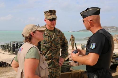 Anne Galegor, a representative of the U.S. Office of Foreign Disaster Assistance, and U.S. Marine Col. Michael V. Samarov, the commander of Joint Task Force-Leeward Islands, speak with a member of the Saint Martin National Gendarmerie at a water distribution site set up by U.S. service members on September 15th. (Photo: U.S. Army Captain Trisha Black)