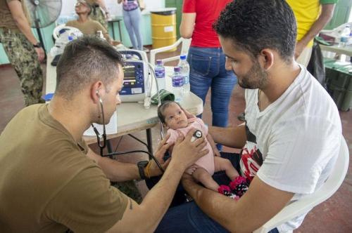 O Terceiro-Sargento médico da Marinha dos EUA Michael Chajon verifica os sinais vitais de uma criança migrante venezuelana em uma unidade médica provisória em La Brea, Trinidad e Tobago. (Foto: Terceiro-Sargento da Marinha dos EUA Bobby J. Siens)